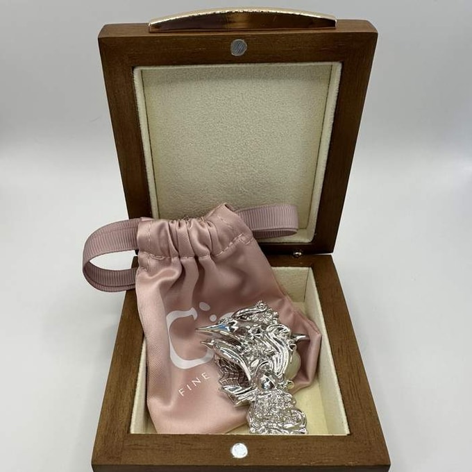 A sample pendant in its satin pouch and wooden keepsake box